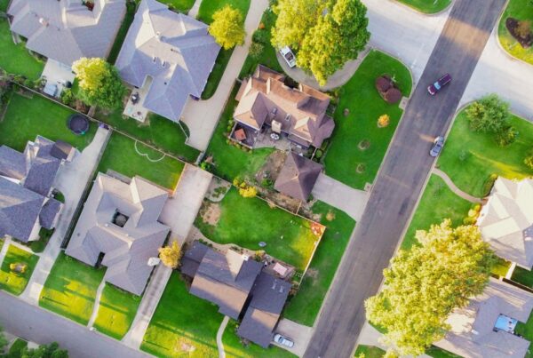 Aerial shot of suburban neighborhood, green grass, and lot boundaries