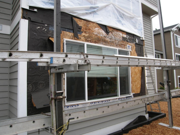 Removal of siding reveals extensive mold, delamination, and rot in the OSB (particle board) wall sheathing.
